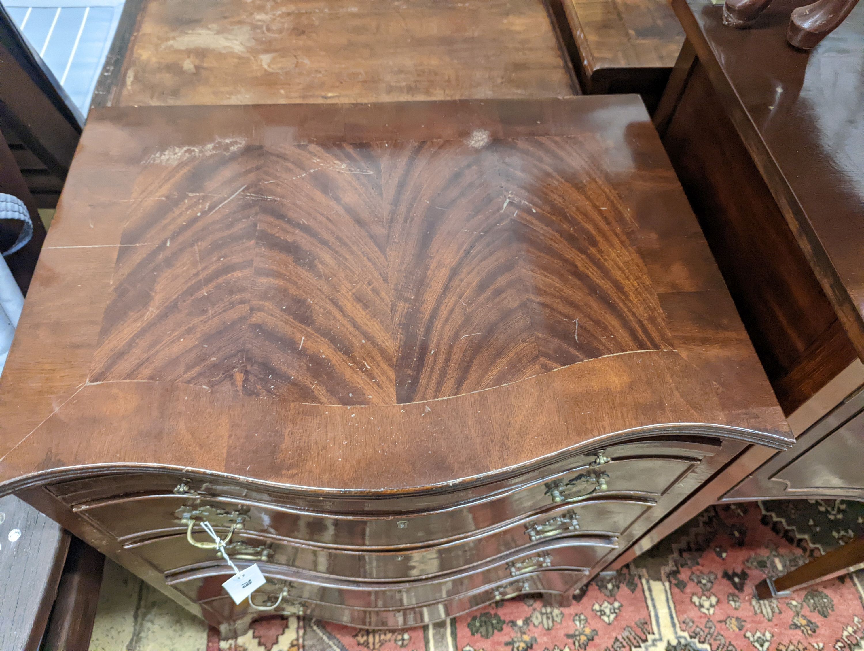 A small reproduction serpentine mahogany chest with slide, width 60cm, depth 44cm, height 77cm